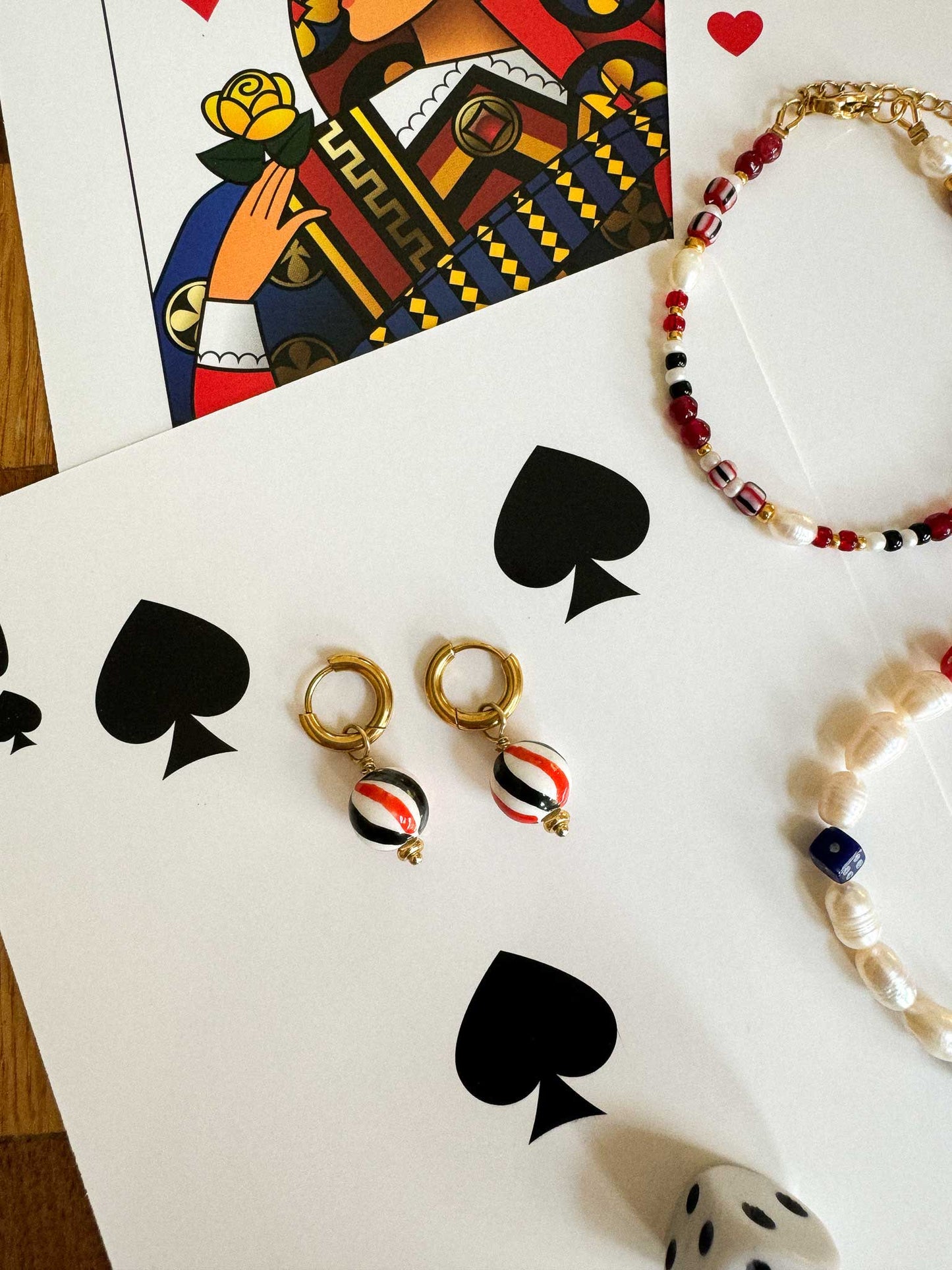 Gouden oorringen met gestreepte kraal rood zwart wit