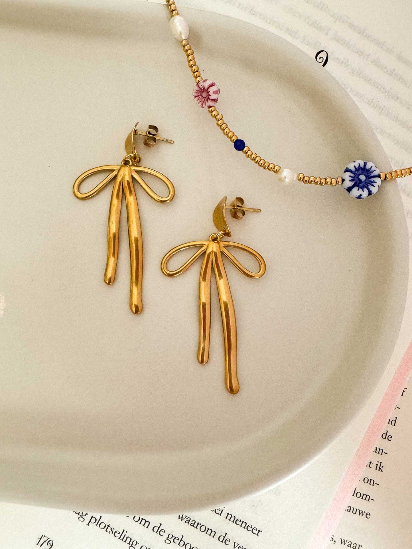 Statement oorbellen met strik goud