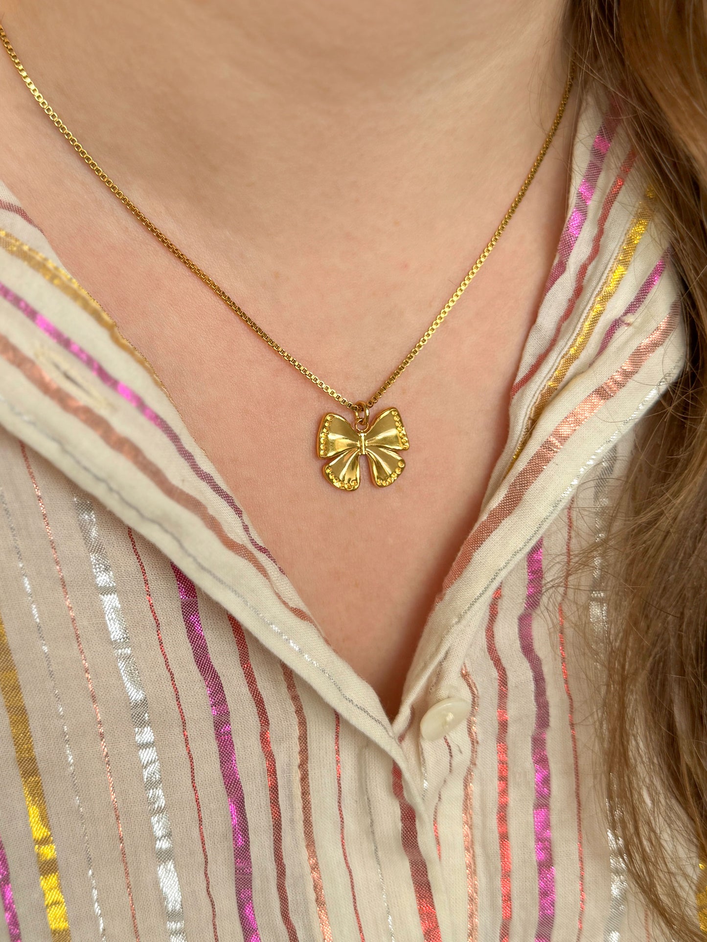 Gouden ketting met bedel in de vorm van een strikje