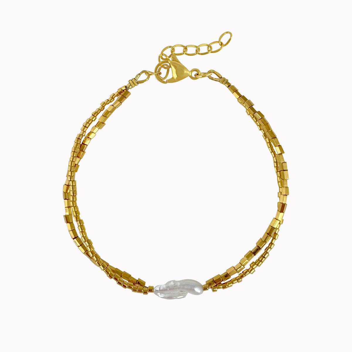 Gouden kralenarmband met fijne kralen en een witte langwerpige parel in het midden.