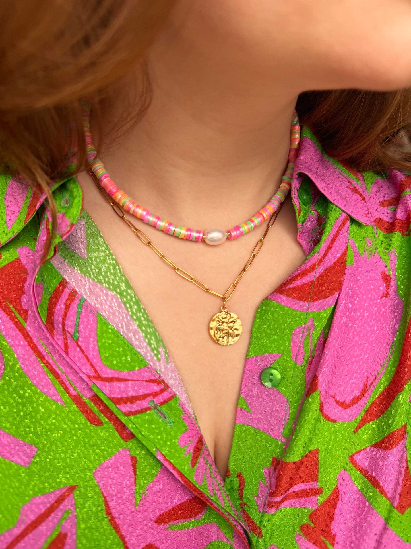 Gouden schakelketting met munt vormige bedel roos