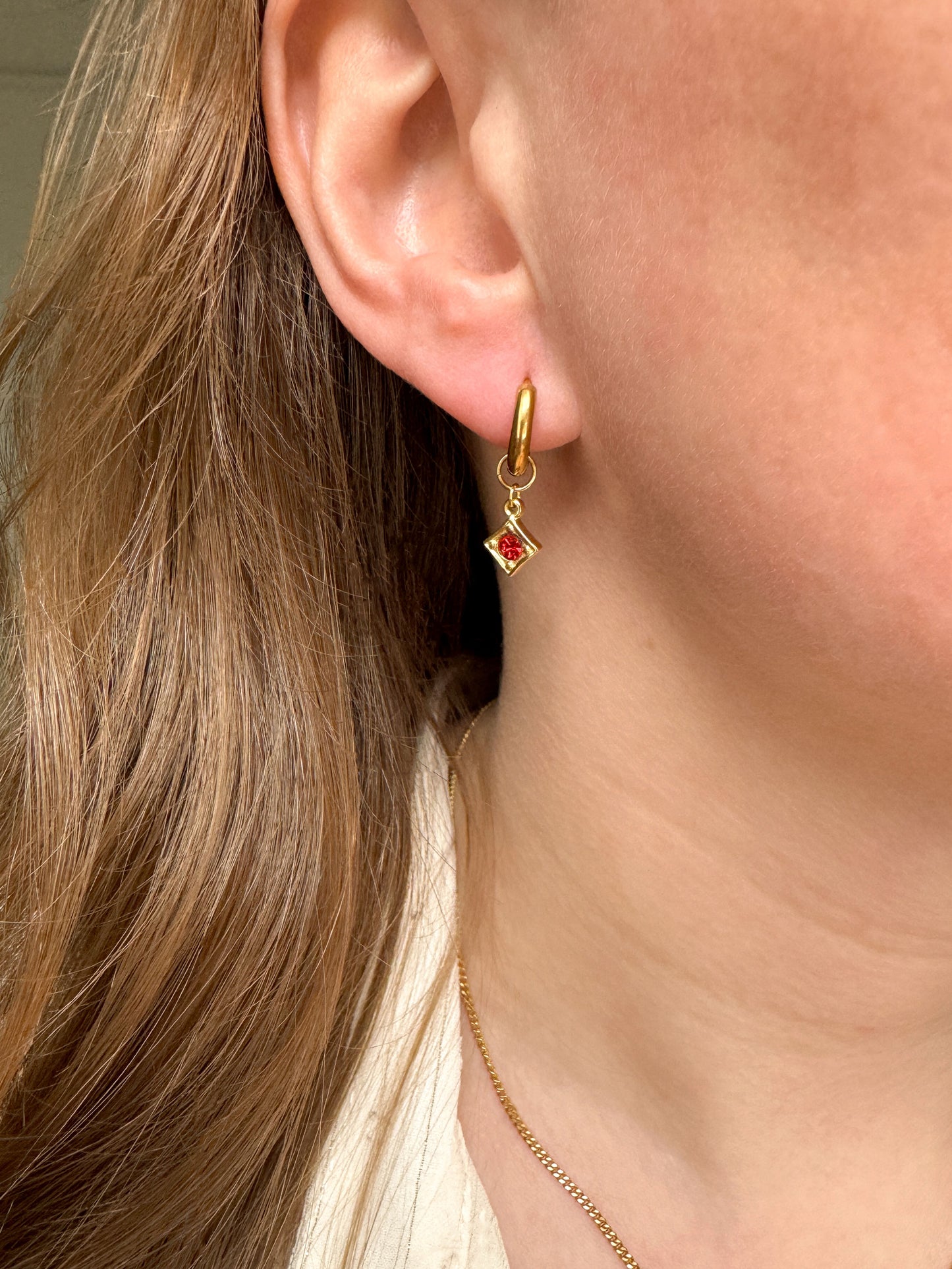 Gouden oorringen met ruitjesbedel en rood steentje