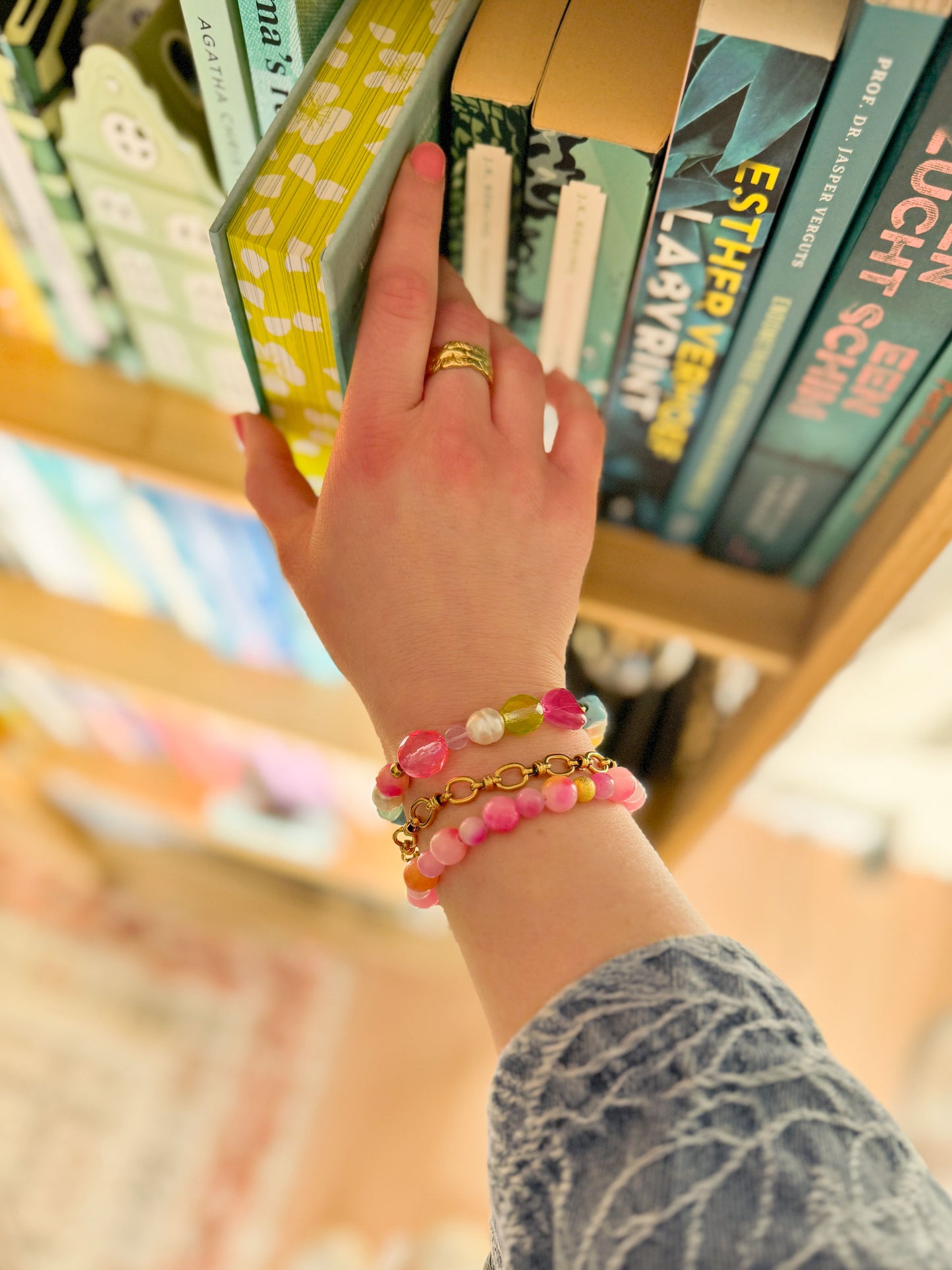 Roze statement kralenarmband gecombineerd met een gouden schakelarmband