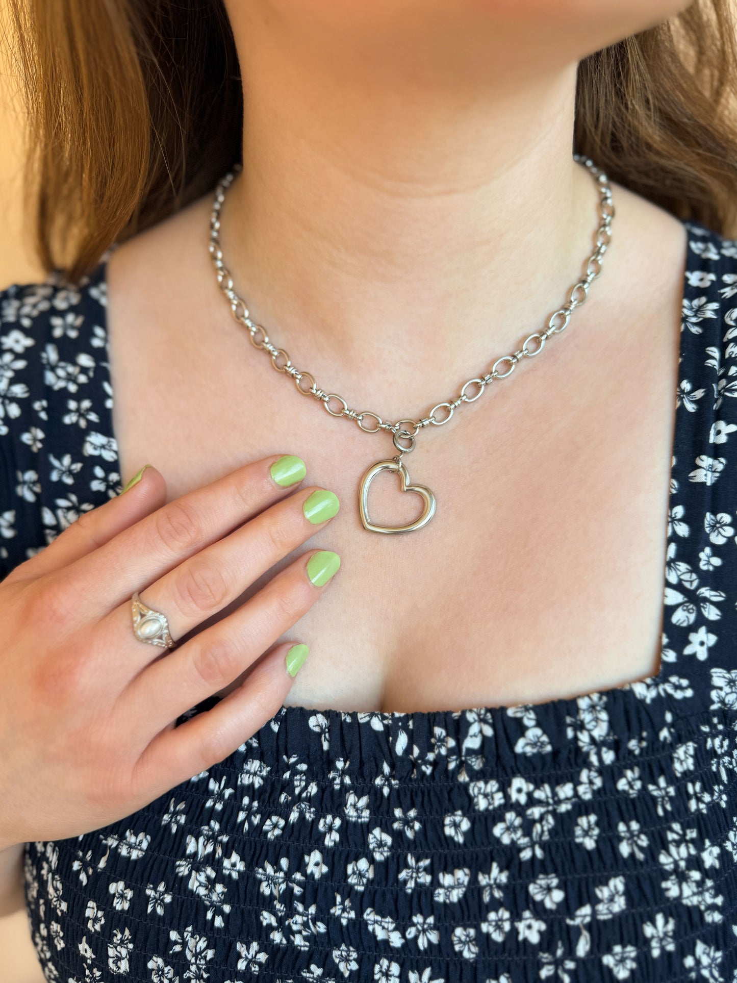 Zilveren schakelketting met daaraan een open hart bedel