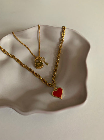 Gouden schakelketting met rood hartje