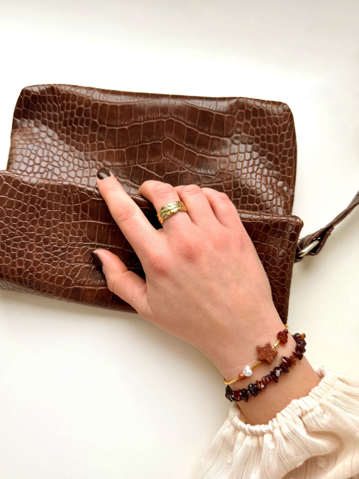 Gouden kralenarmband met bruine sterbedel