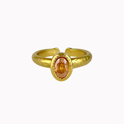 Gouden verstelbare ring met ovale champagnekleurige steen in een goudkleurige setting met subtiele gehamerde structuur.