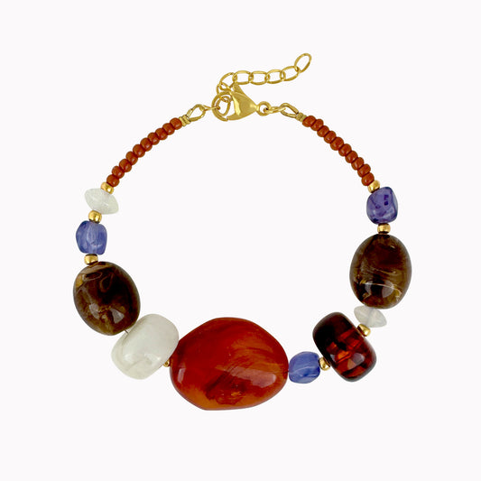 Terracotta kralenarmband met grote bruine, oranje en crèmekleurige kralen, paarse accenten en gouden details.