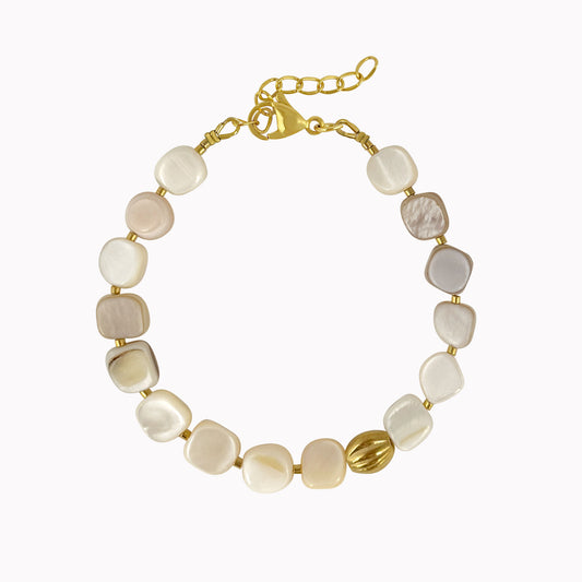 Crèmekleurige kralenarmband met vierkante schelpkralen, gouden tussenkralen en een ovale gouden accentkraal.