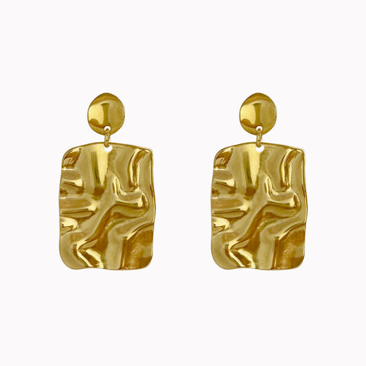 Gouden statement oorbellen met rechthoekige hangers, een golvende structuur en glanzende afwerking.