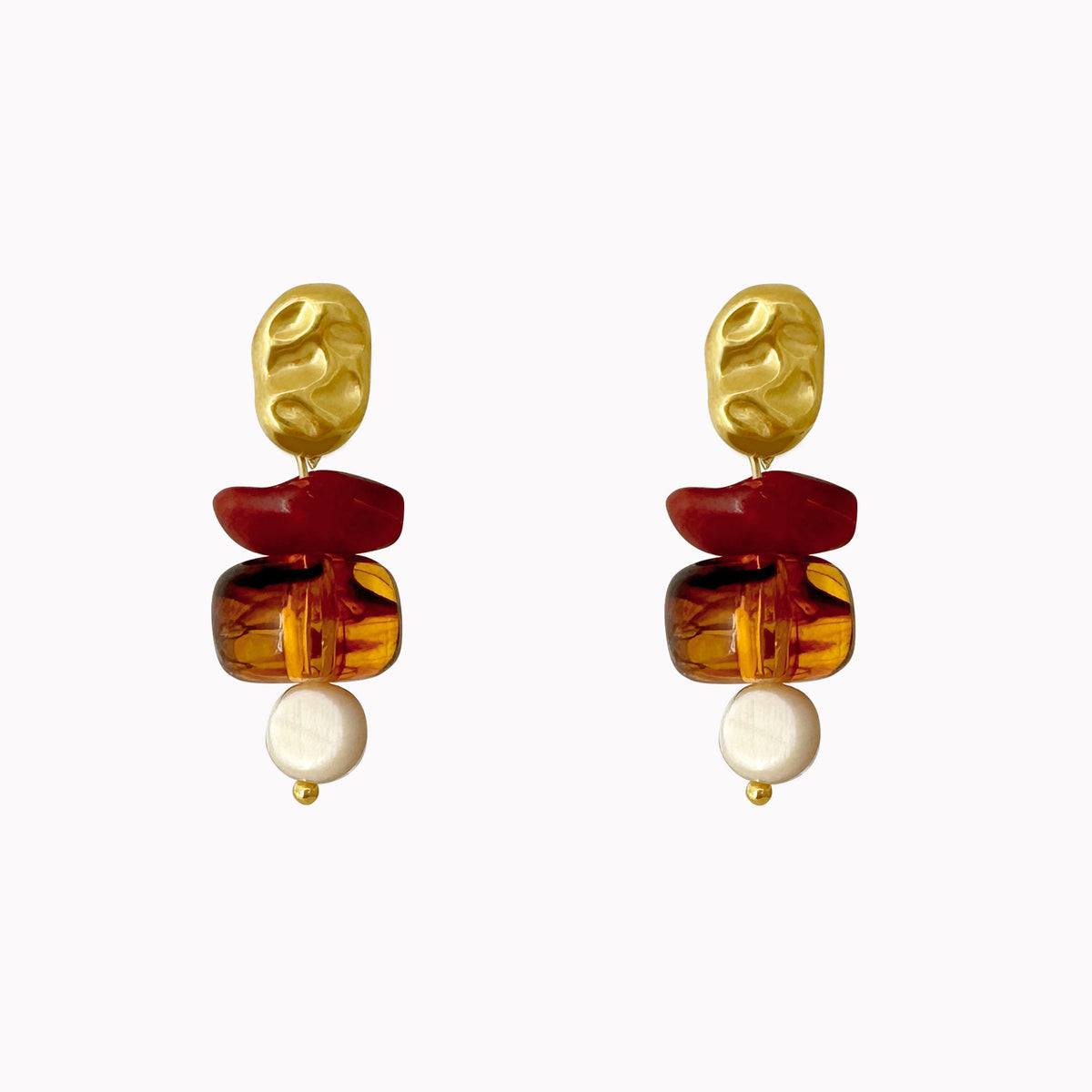 Statement oorbellen met gouden organische oorstekers en hangers van terracotta, bruine en witte kralen.