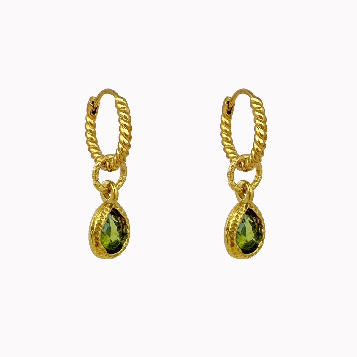 Gedraaide gouden oorringen met kleine groene druppelvormige stenen in een goudkleurige zetting.
