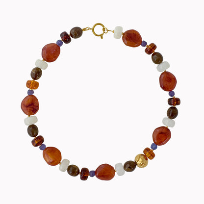 Handgemaakte terracotta kralenketting met bruine, witte en paarse kralen en goudkleurige details.