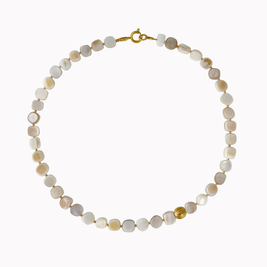 Crèmekleurige kralenketting met kleine vierkante schelpkralen, gouden tussenkraaltjes en een opvallende gouden kraal.
