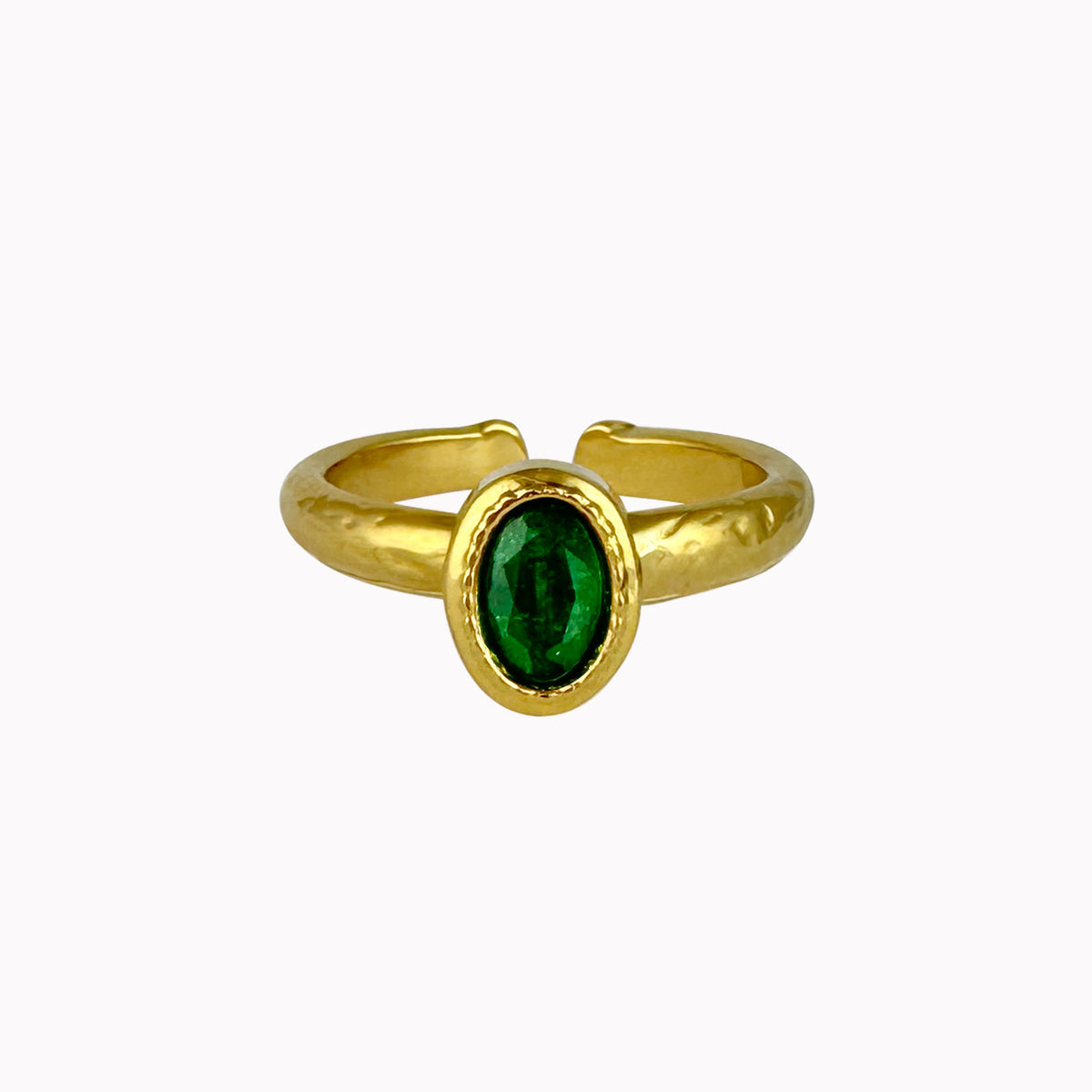 Gouden verstelbare ring met ovale donkergroene steen en een licht gehamerde afwerking.