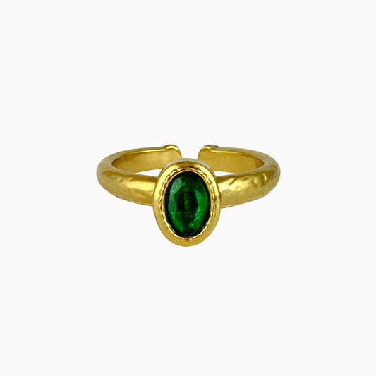 Gouden verstelbare ring met ovale donkergroene steen en een licht gehamerde afwerking.
