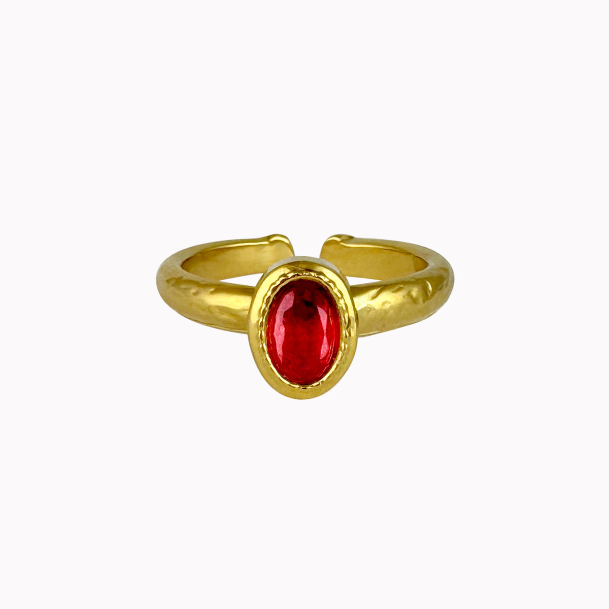 Gouden verstelbare ring met ovale rode steen in een goudkleurige setting met licht gehamerde structuur.