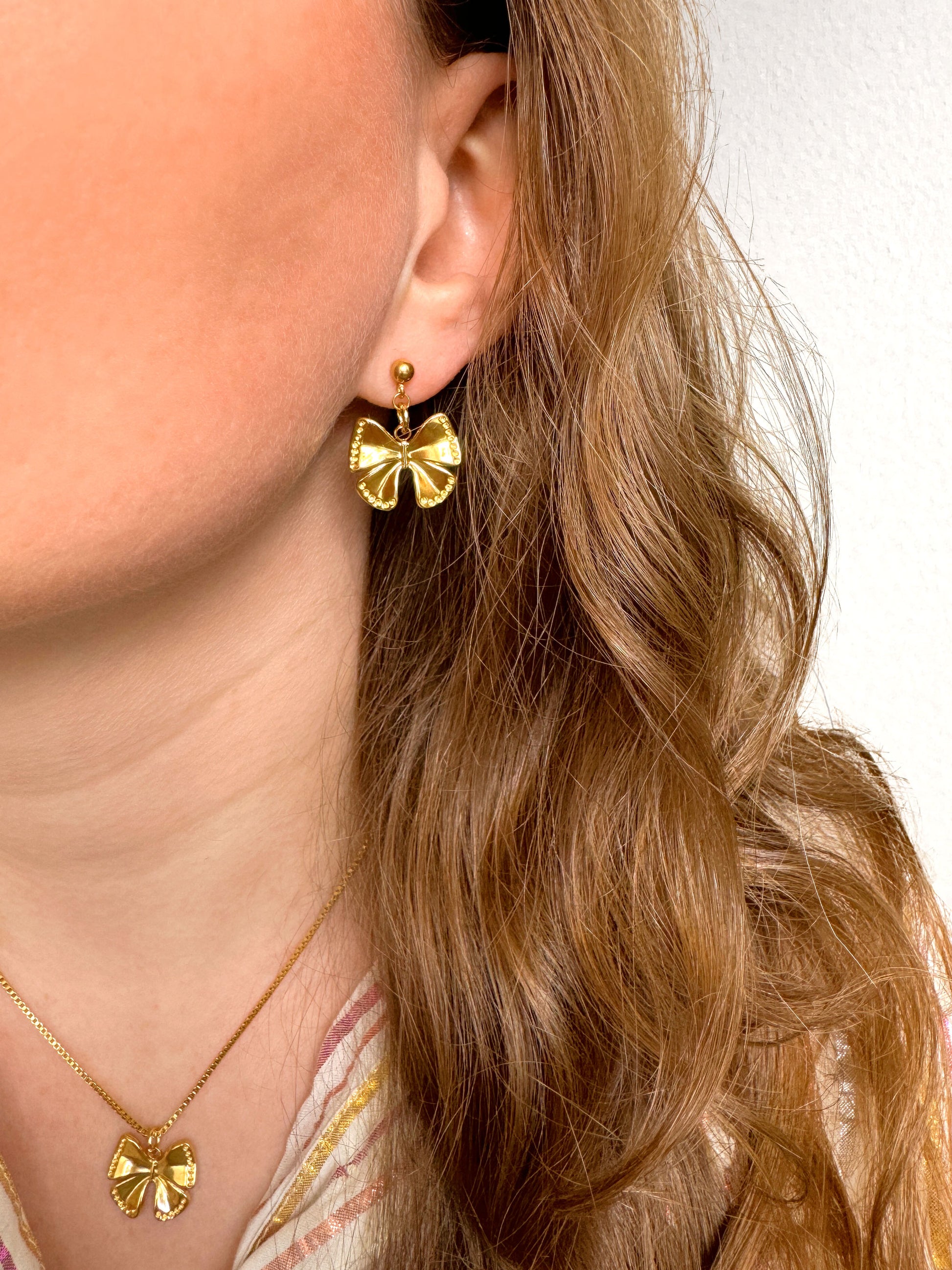 Gouden oorhangers met strikbedel