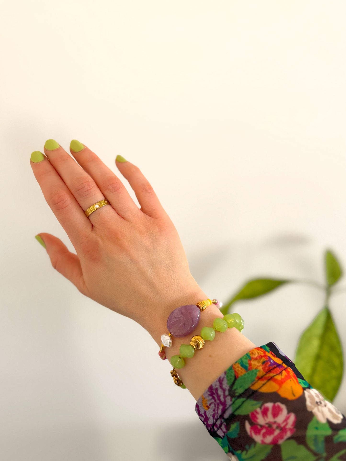 Groene statement kralenarmband gecombineerd met armband met paarse steen