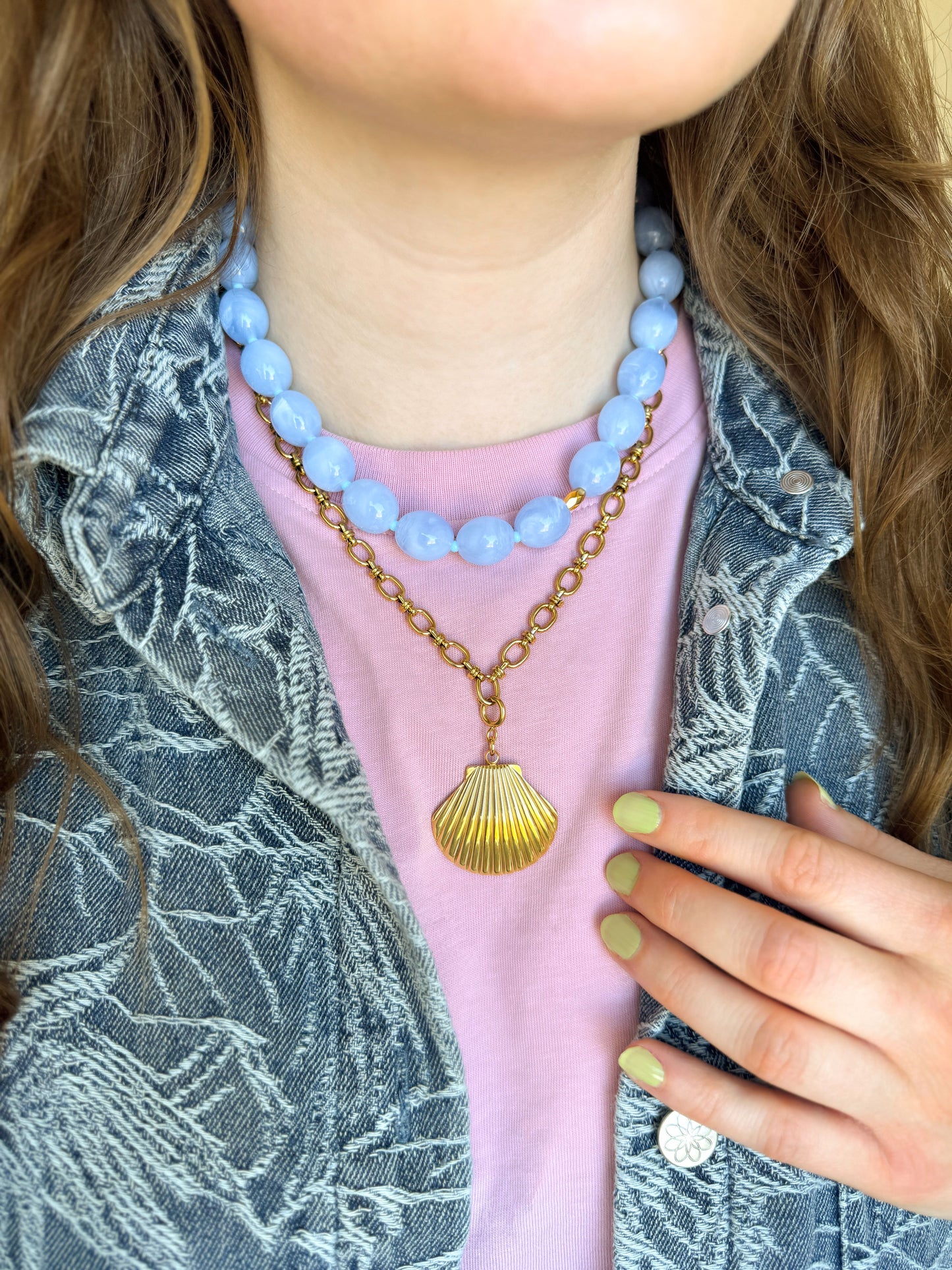 Blauwe kralenketting gecombineerd met een gouden schakelketting en schelp bedel