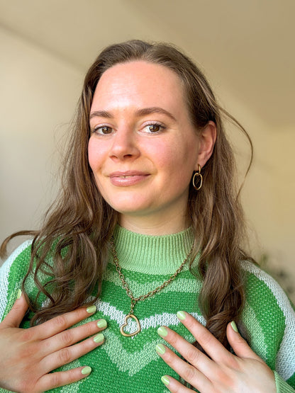 Sieraden set van een gouden schakelketting met hartjesbedel en oorringen met ovale bedel