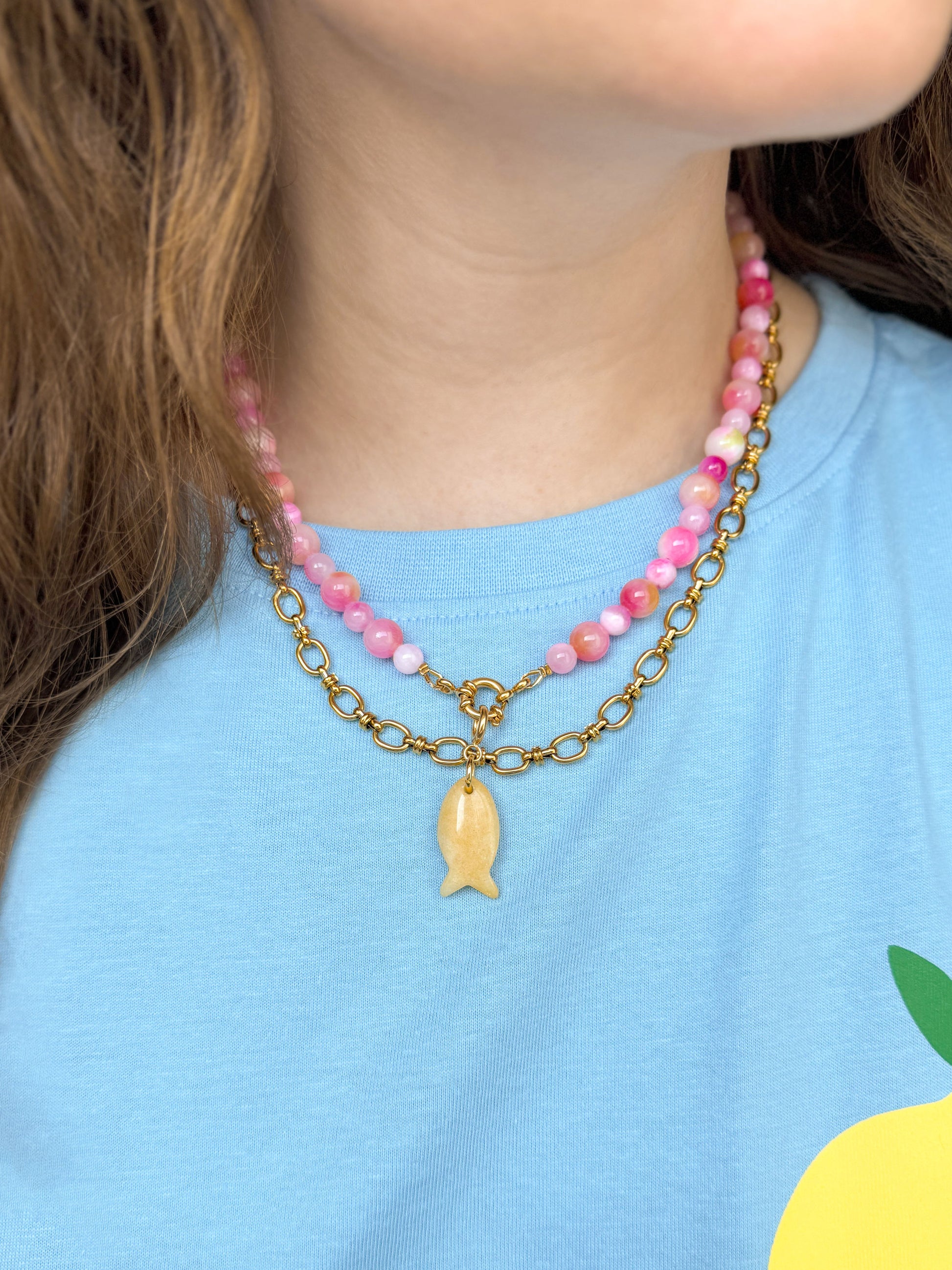 Gouden schakelketting gecombineerd met een roze kralenketting met visbedel