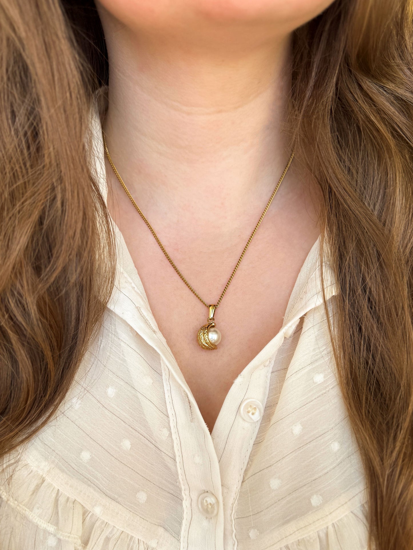 Close-up van gouden minimalistische ketting met parel bedel